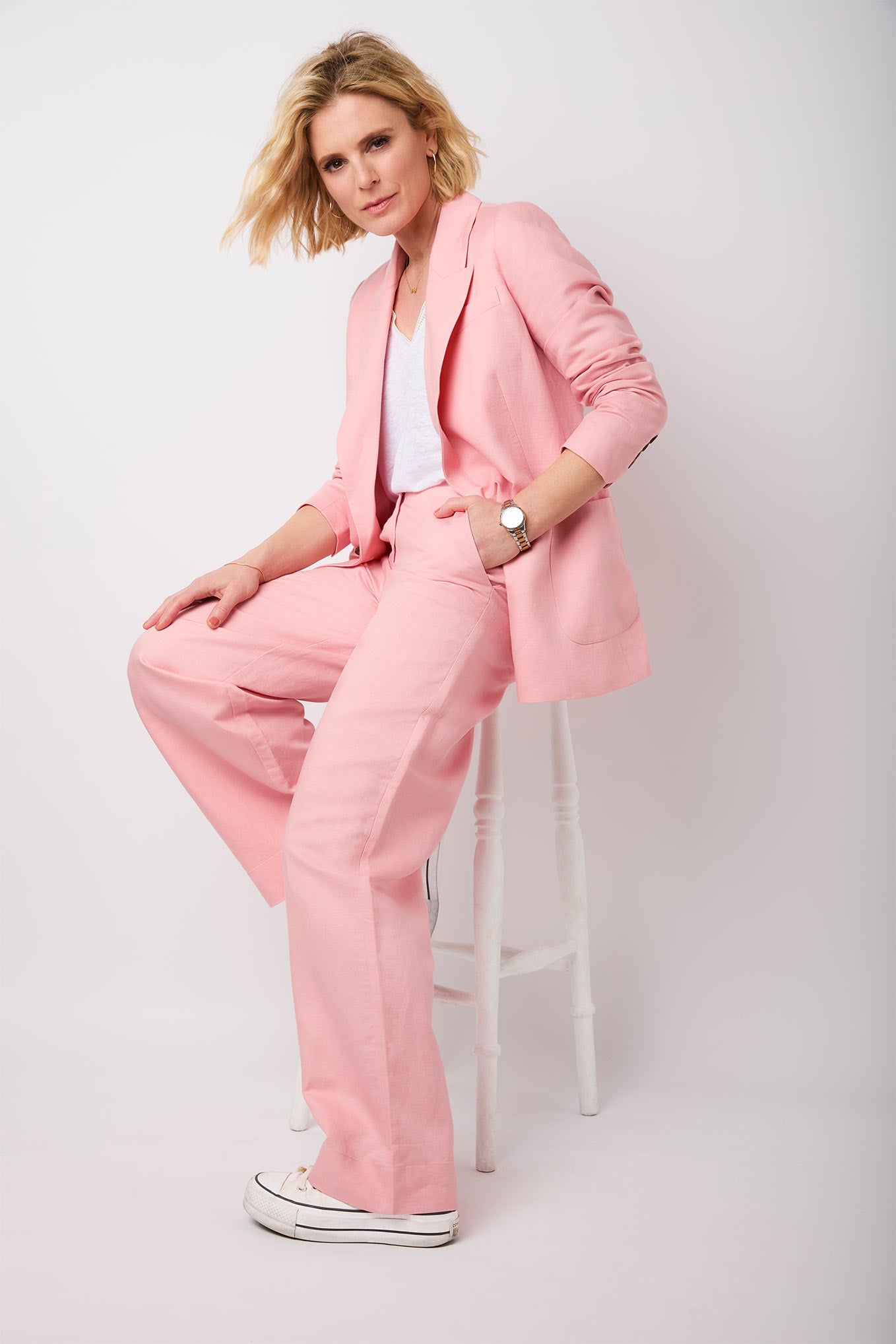 Premium Photo  An adult woman in a bright pink trouser suit and a white  top poses on a city street